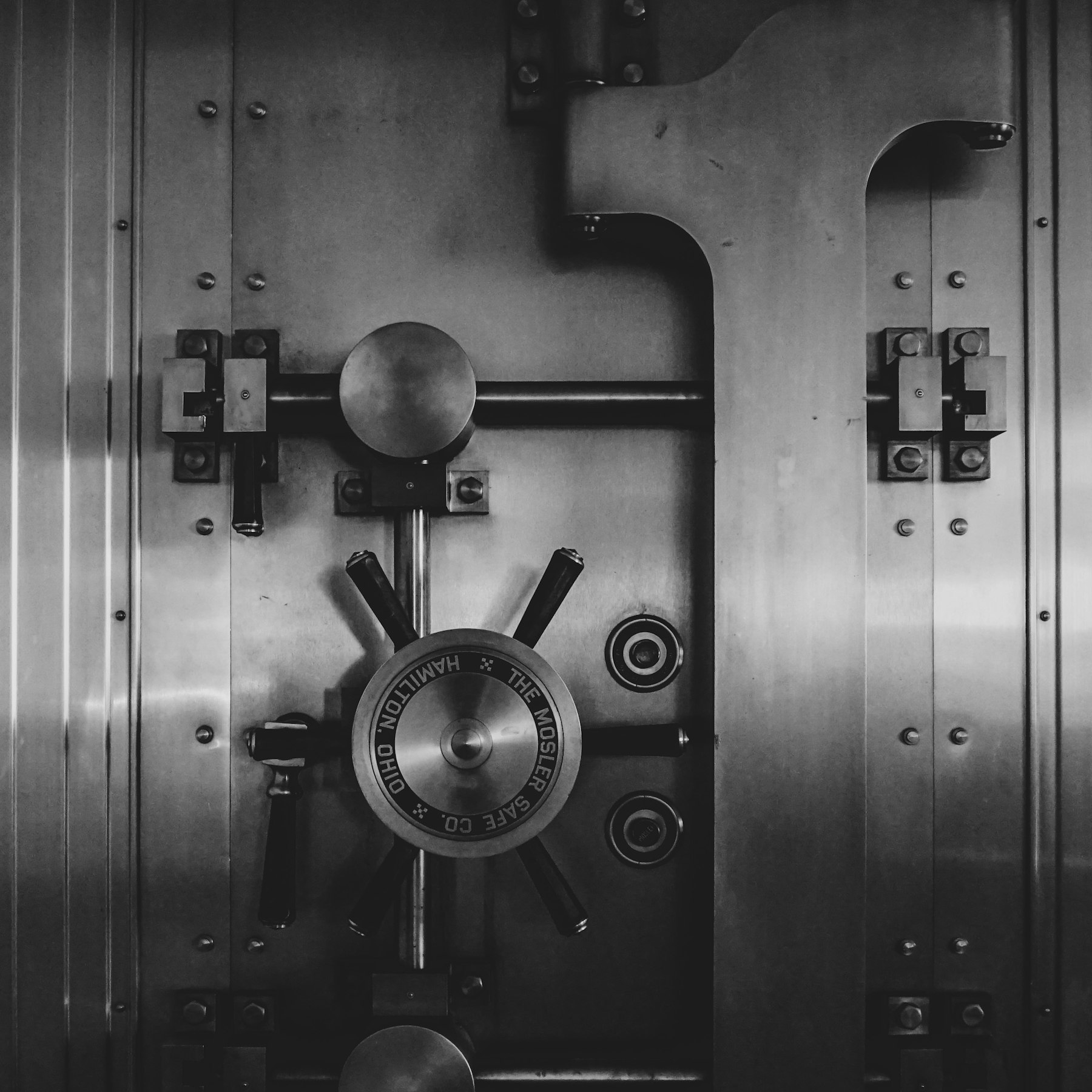Heavy steel bank vault door with a circular locking wheel